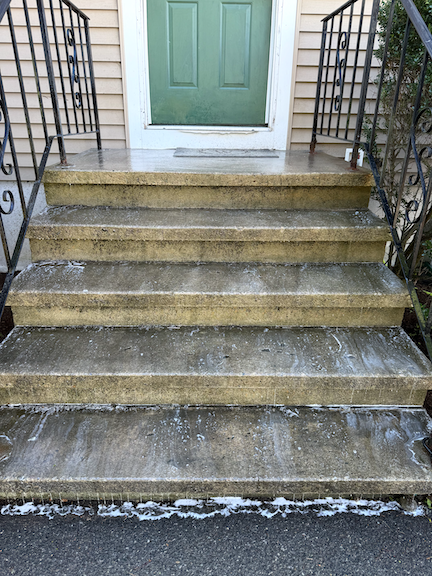 Before: Concrete front steps in Randolf, MA with visible dirt, grime, and organic buildup before professional pressure washing.