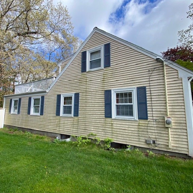 Before: Vinyl siding in Weymouth, MA with heavy green mildew and algae growth.