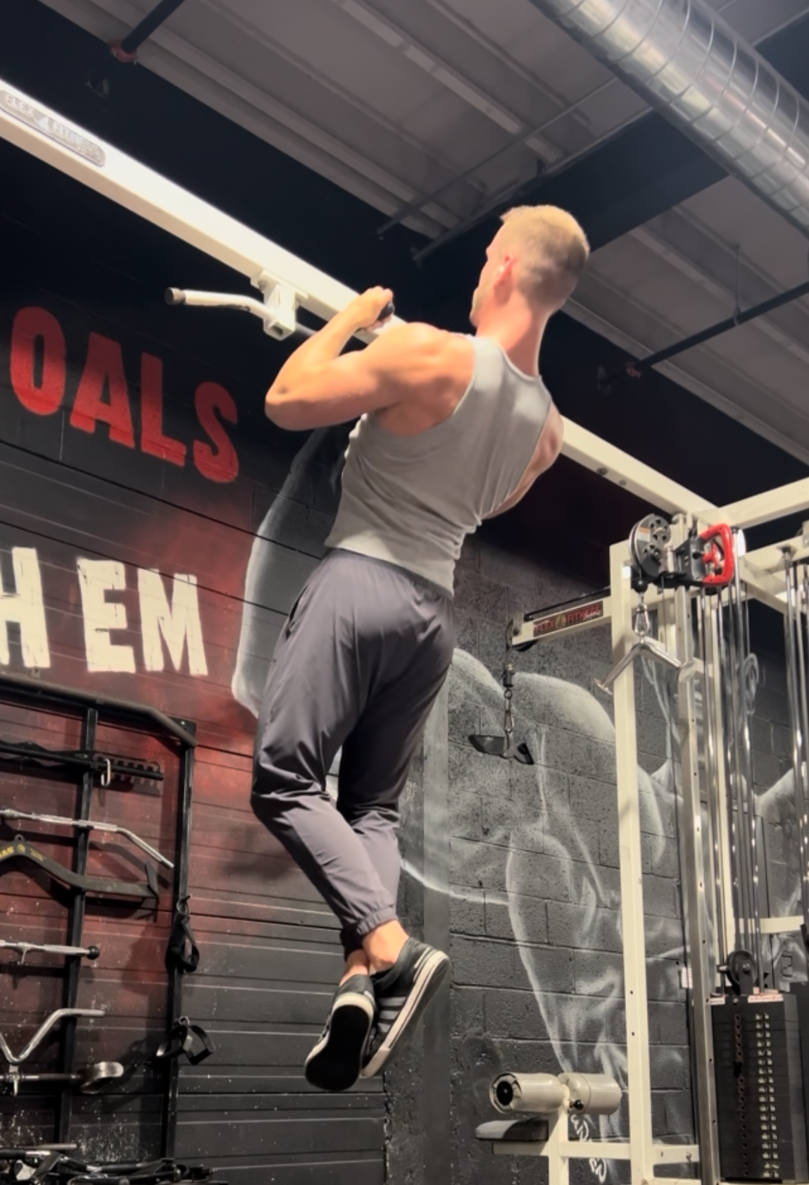A man performing a pull-up exercise at the gym.