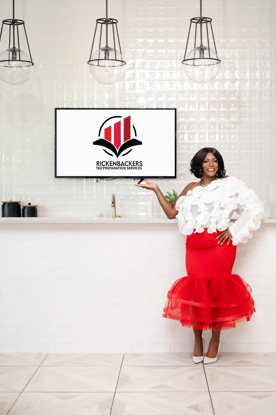 CEO smiling and pointing to a television screen the logo "Rickenbackers Tax Preparation Services."