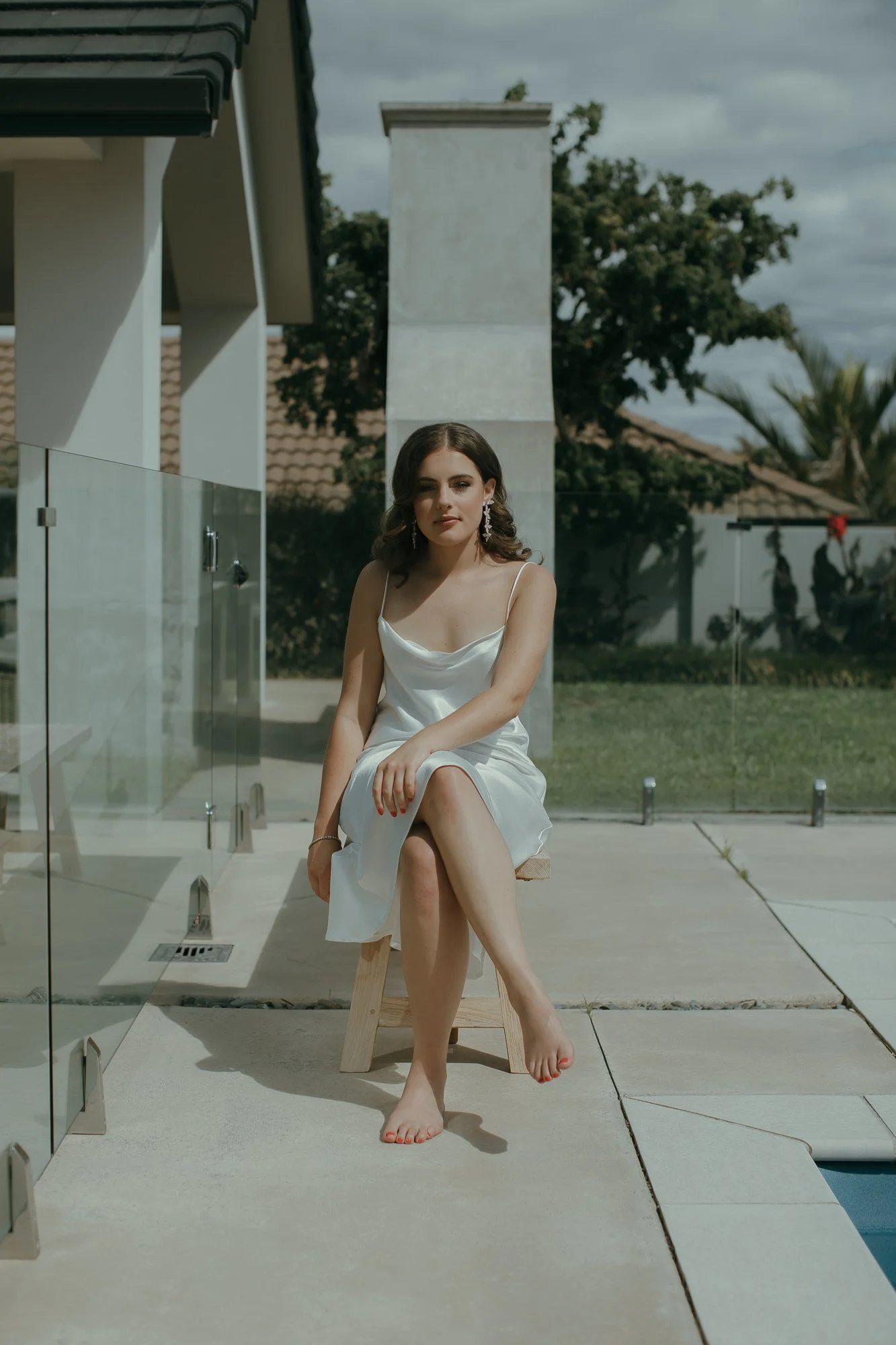 Hope before her wedding sitting on a chair by the pool