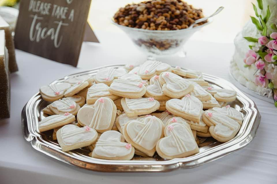 Heart-shaped cookies with white icing and small pink decorations on a silver tray. Dream Day Event Rentals, Vintage and Modern Decor and Floral Rentals, Freeport Illnois.