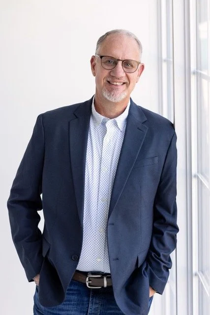 Kendall Layman Founder of The Gooder Life posed against a wall for a professional headshot 