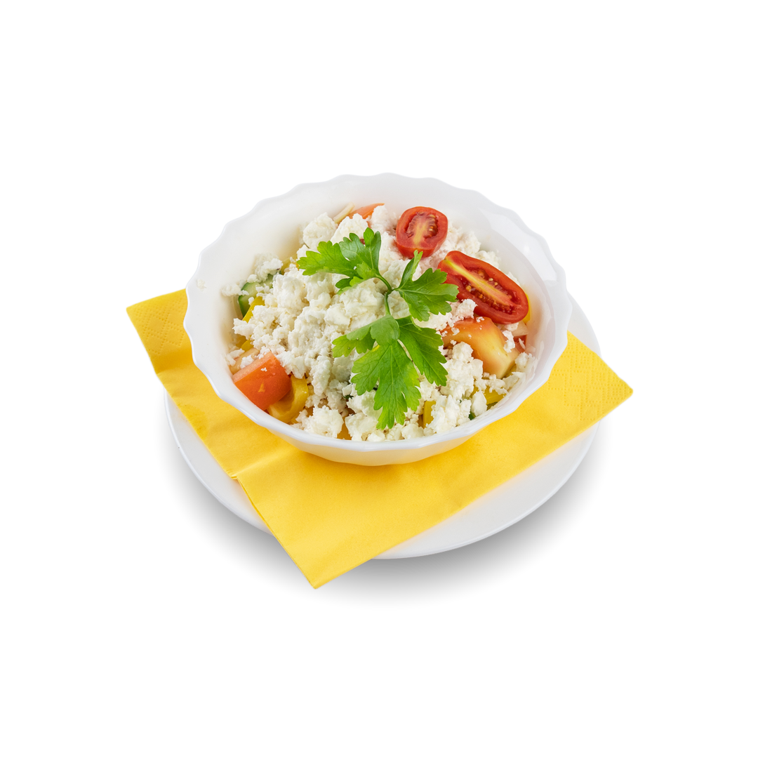 Salat mit Tomaten, Käsekrümeln und Petersilie auf einem weißen Teller mit gelbem Papier in schwarzem Hintergrund.