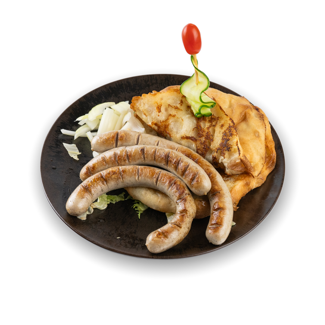 Ein Teller mit Bratwurst, Kartoffelpuffer, gewürfeltem Kohl und einer Kirsche auf einem Holzspieß, vor schwarzem Hintergrund.