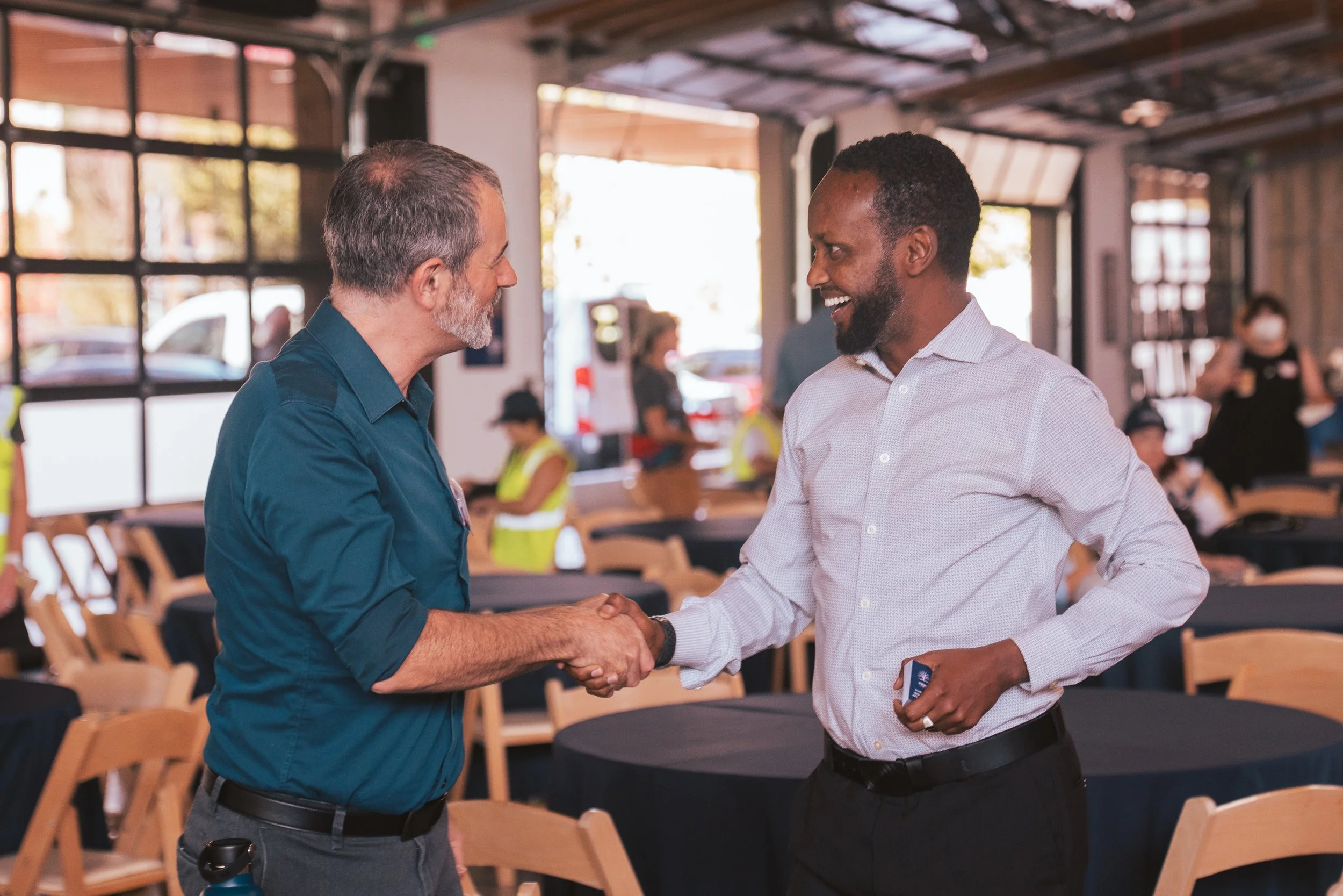 Two individuals greeting each other at a PCEF event.