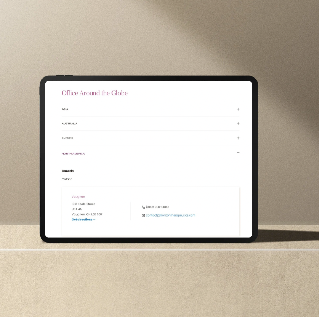 A tablet displaying a world office directory on a light-colored surface.