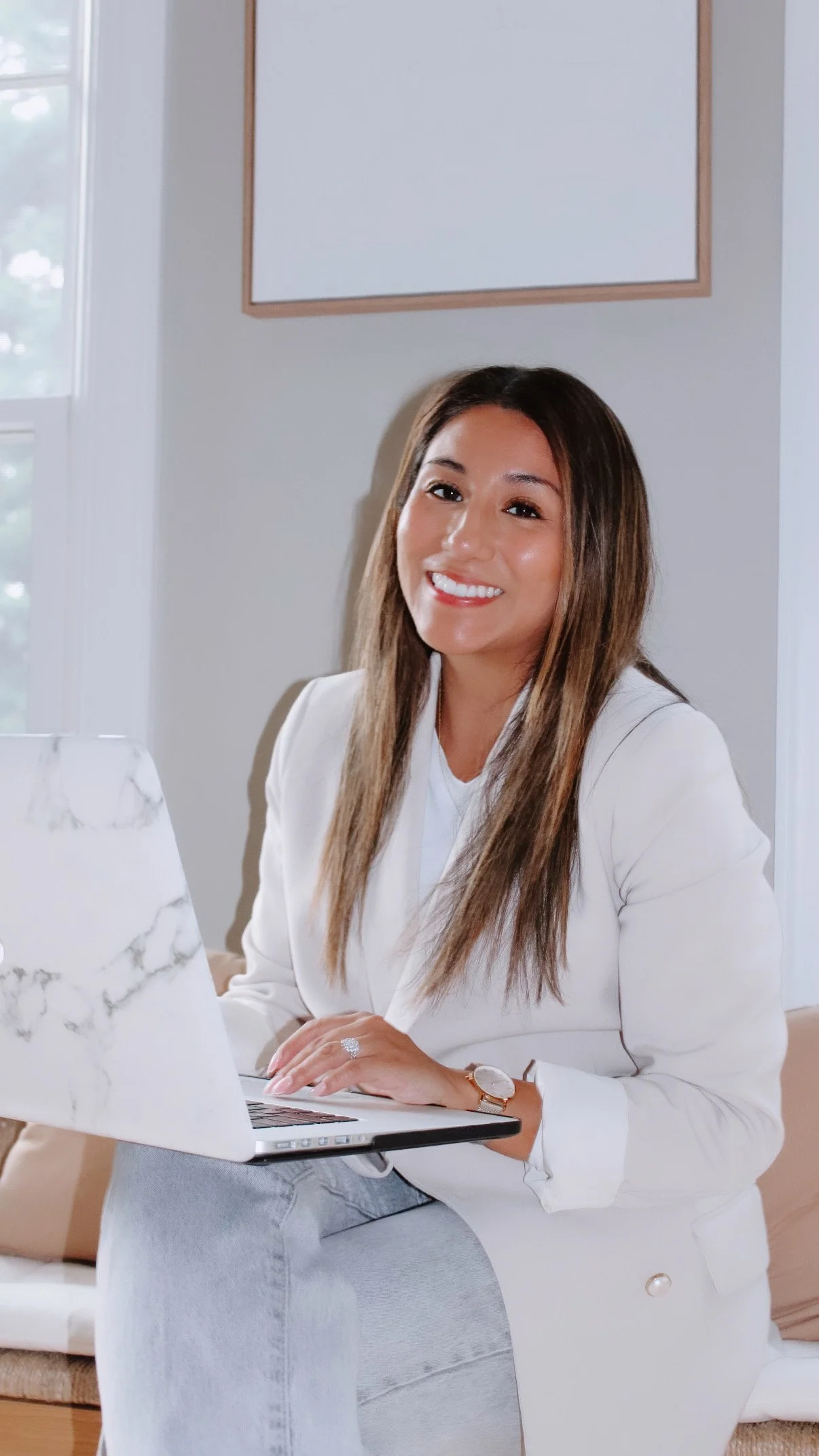 Portrait of Vicky Gorman, designer, with her laptop in a bright workspace.