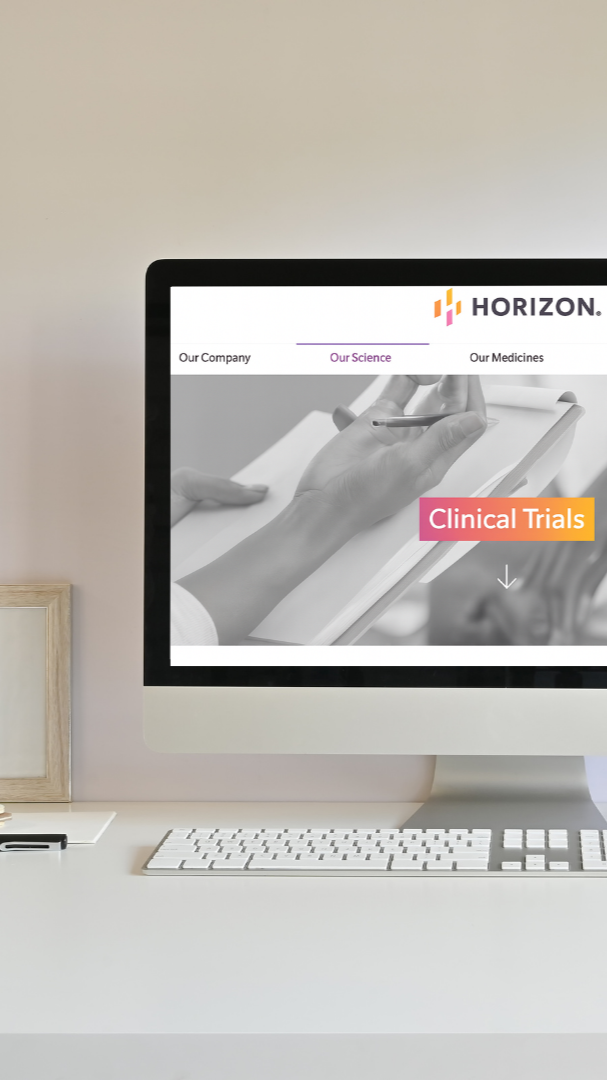 Computer screen displaying the Horizon logo and a webpage with the text "Clinical Trials" button. The webpage features a grayscale image of a hand writing on a notepad.