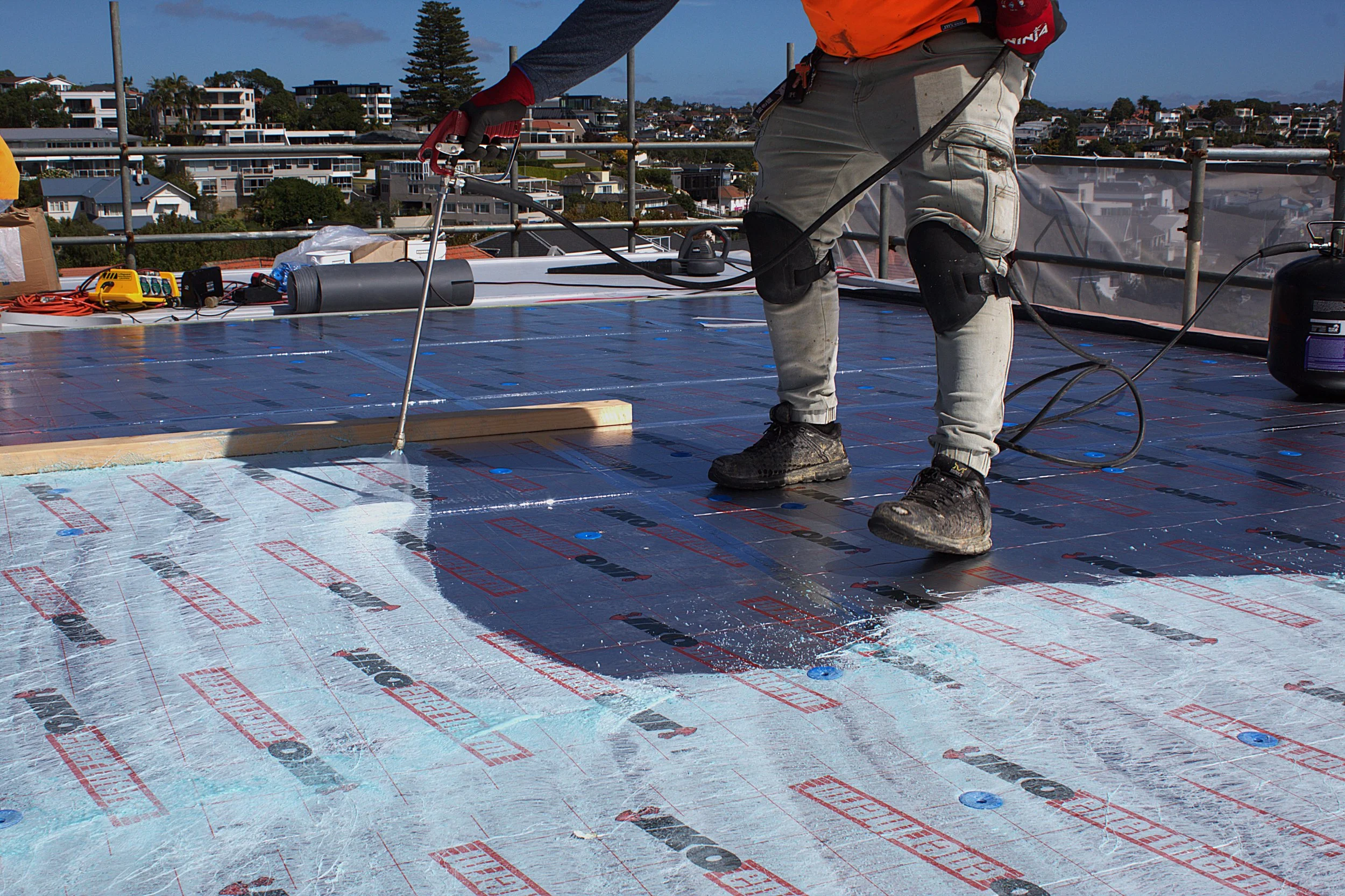 MPM Waterproofing applicator spray-applying liquid membrane to flat roof, Auckland