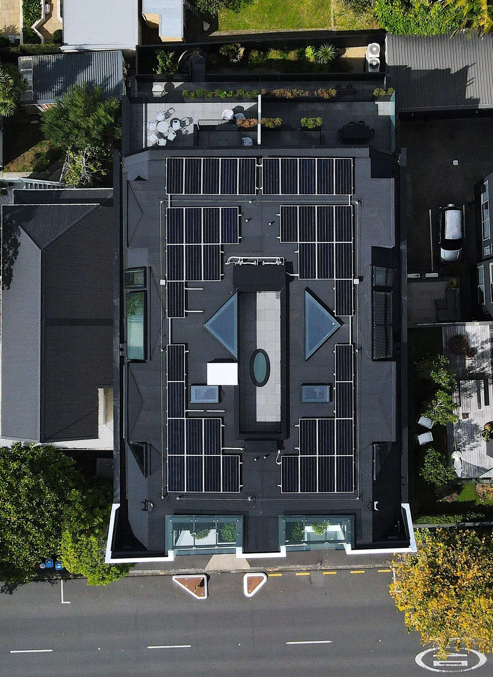 Aerial view of completed membrane roof with solar panels on Auckland residential building