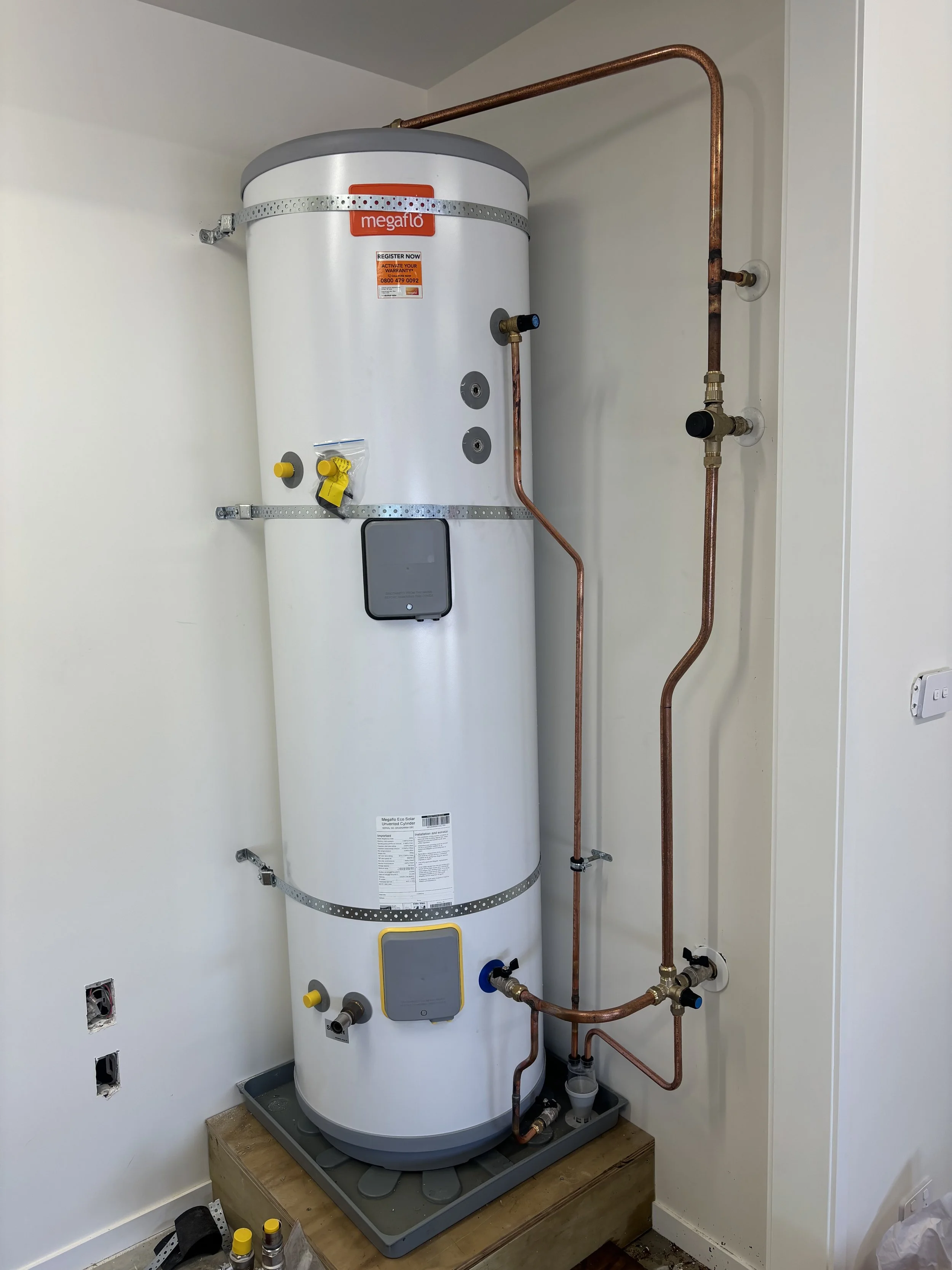 A person tightening a plumbing fitting on a toilet tank using a wrench.