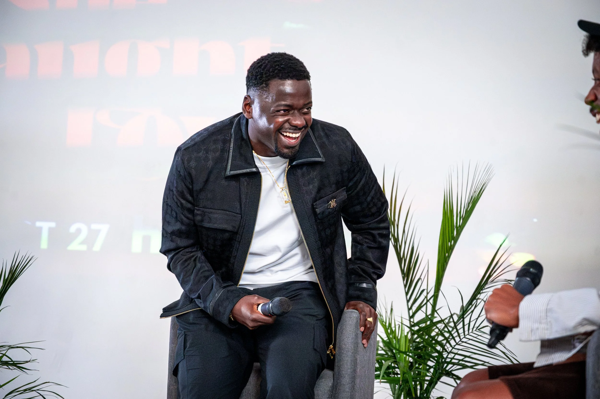 Portrait of a prominent Black actor laughing while speaking on a panel during a movie premiere event, photographed by HigherLXNG. A candid moment highlighting personality, presence and creative storytelling.