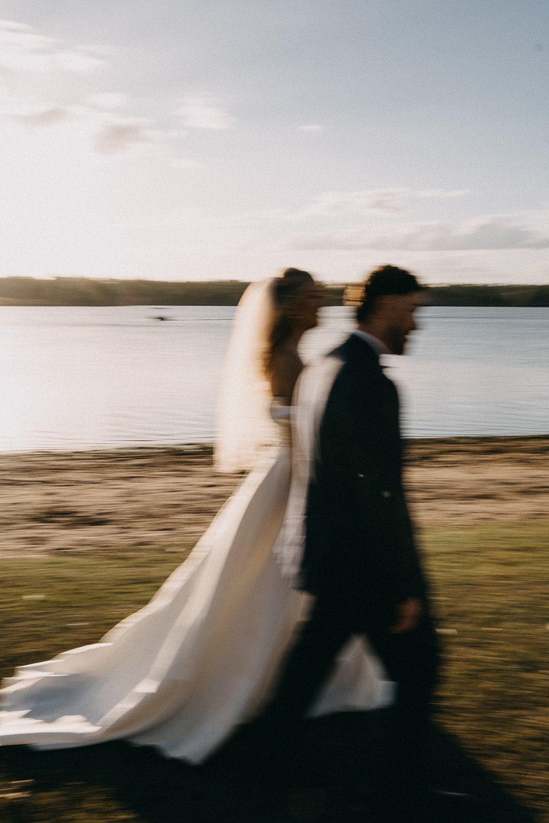 Artistic blurred photo of bride and groom waterside at Lake Dyer