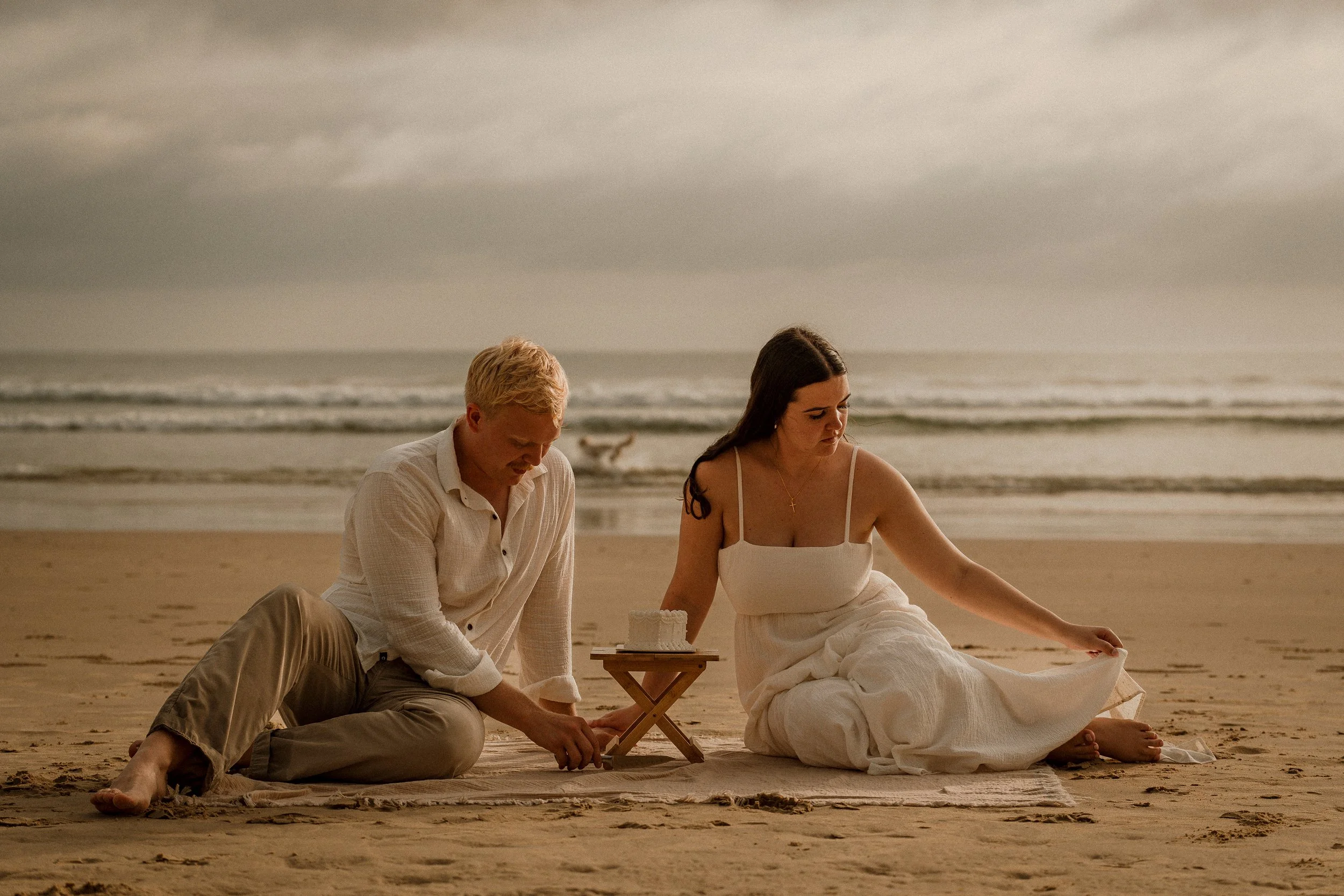 Bride and groom enjoy cake and picnic on the beach after portraits on Sunshine Coast