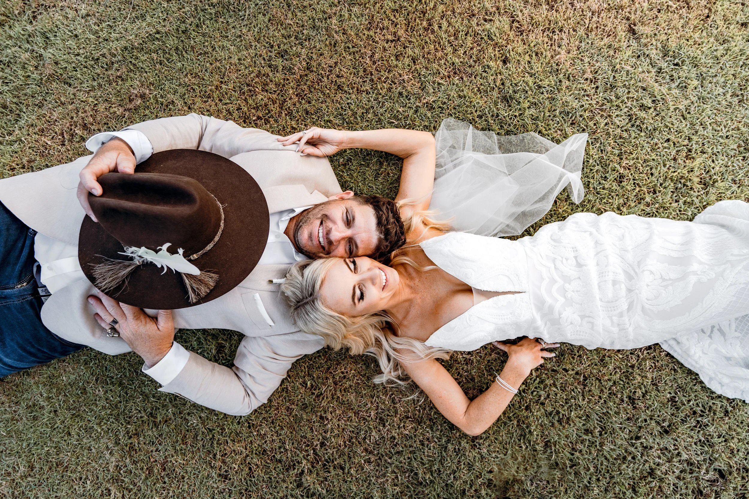 Couple laying in grass for sunset portraits after country wedding in Sunshine Coast hinterland