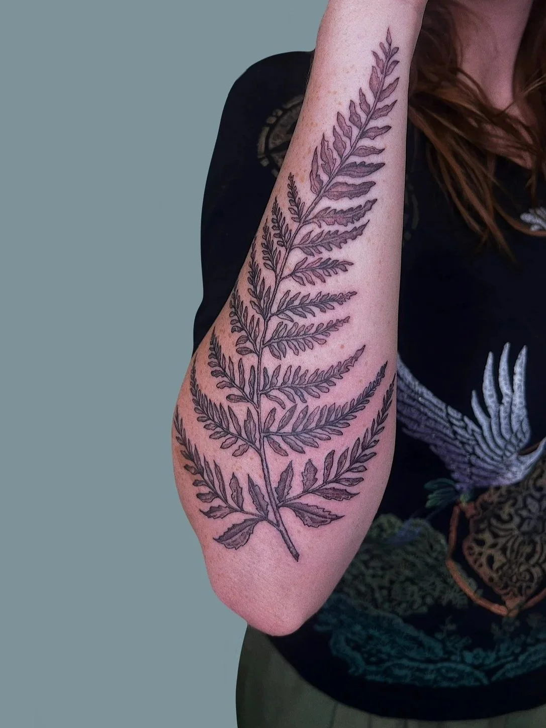Tattoo of a detailed fern leaf on the inner forearm of a person with light skin.