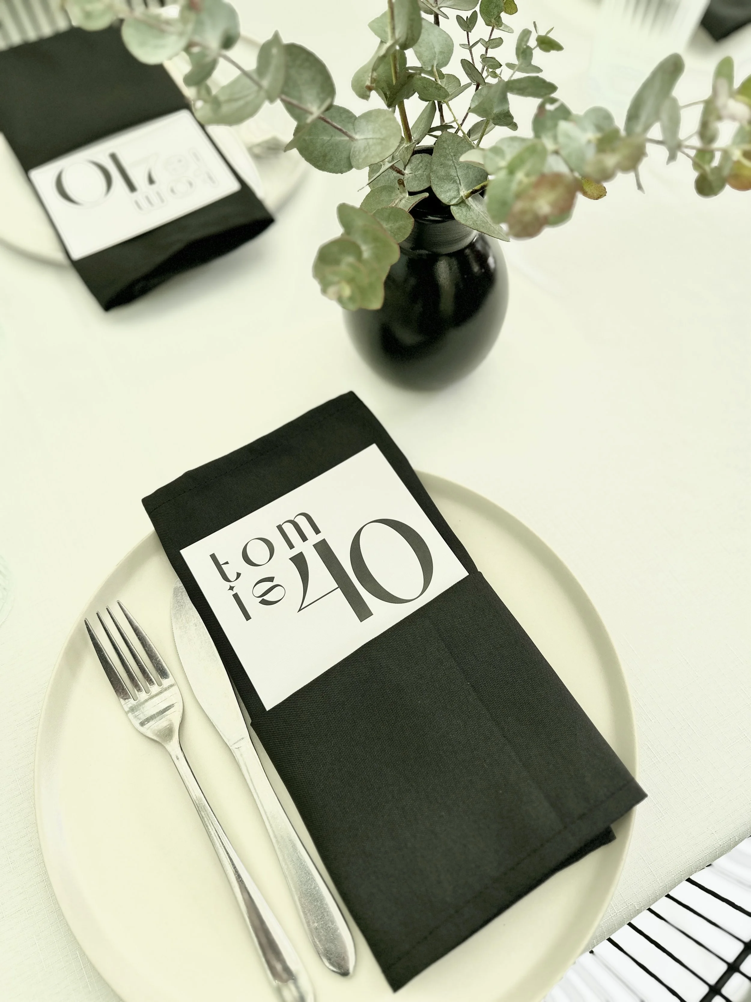 A food menu styled on a plate at Sublime Social, Clarence Park. There is native foliage in small black vase. Designed by Nutmeg Creative. Sublime Café & Catering, Adelaide South Australia