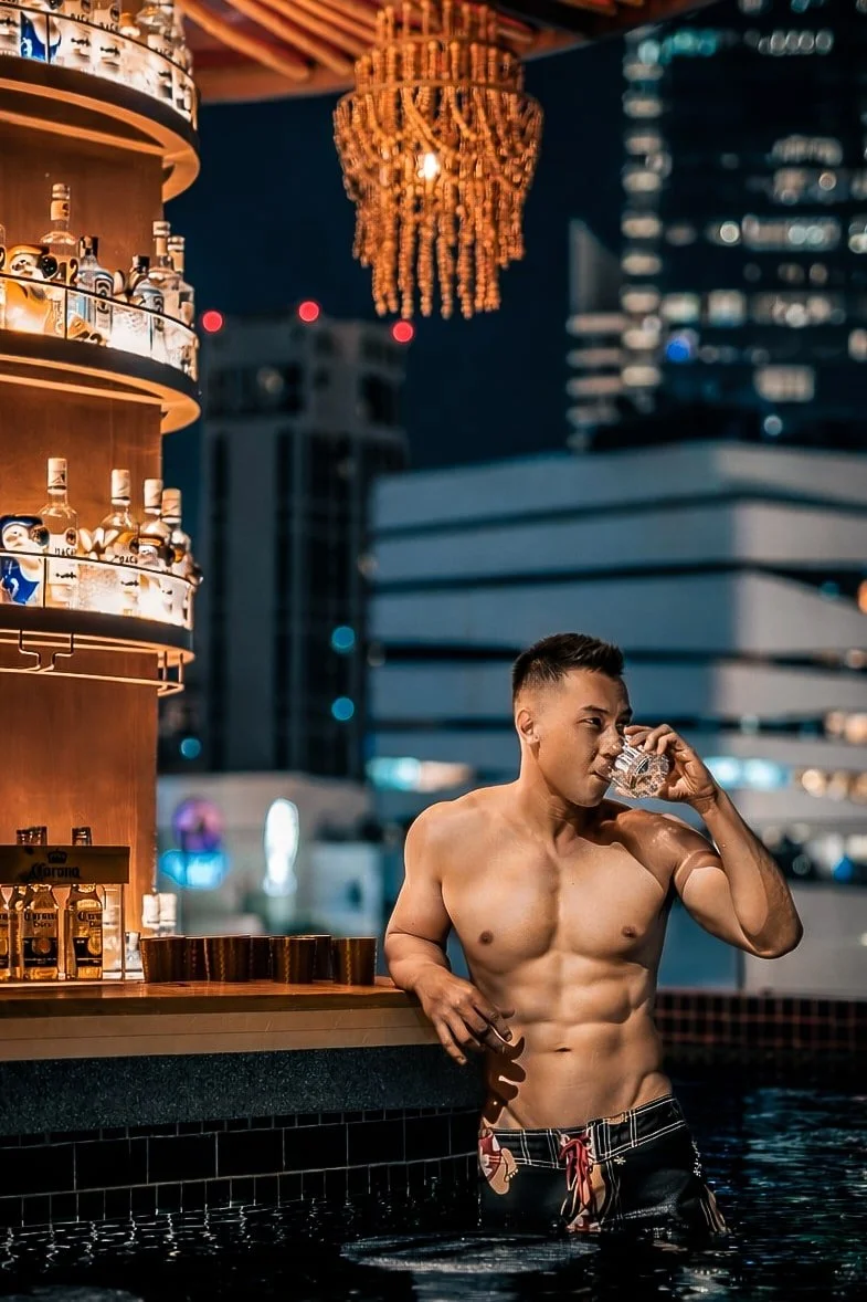 bangkok-rooftop-pool-lifestyle-portrait-shirtless-man-drink.jpg