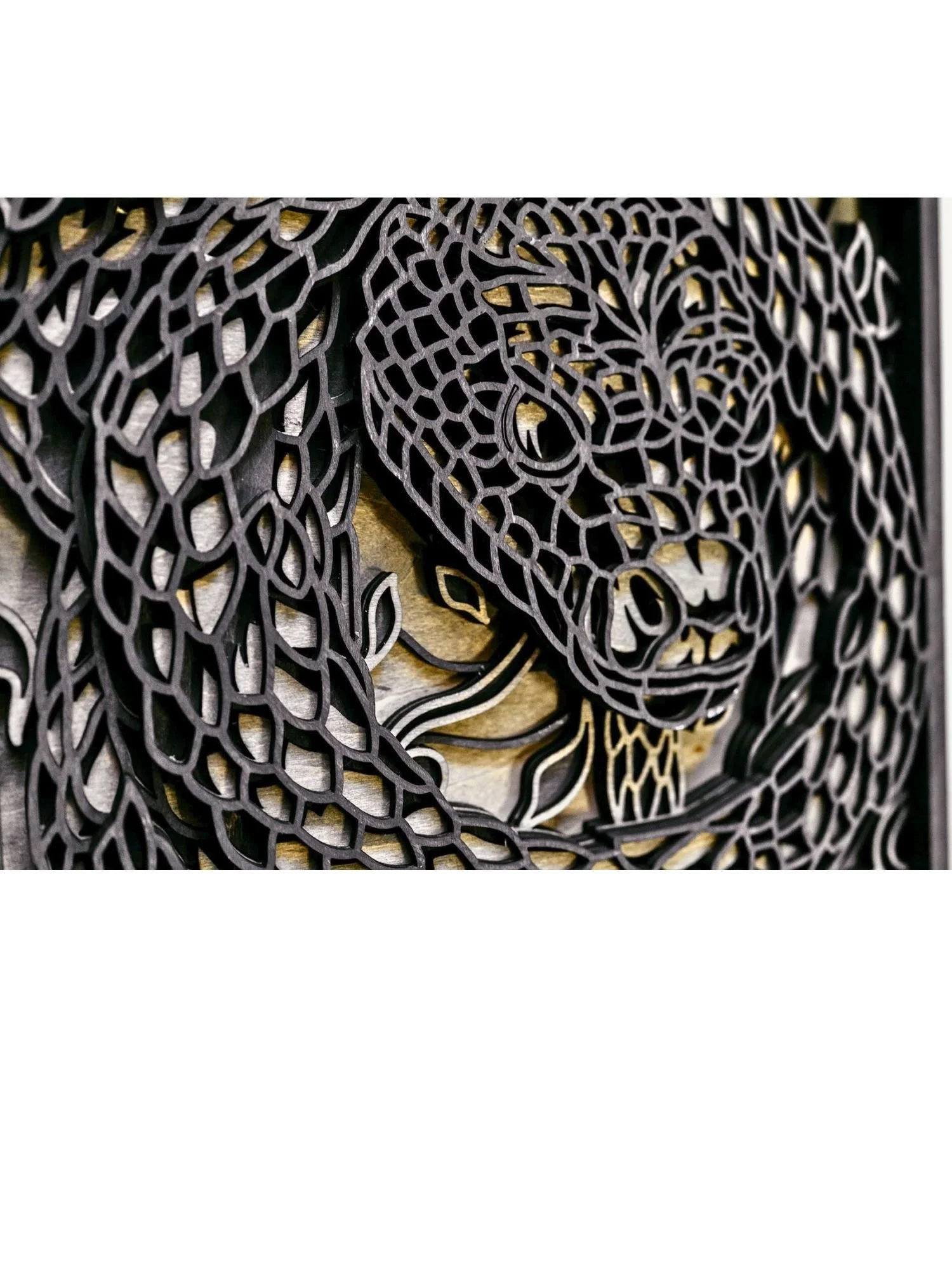 Close up of snake wood wall art showing laser cut scale detail and layered craftsmanship