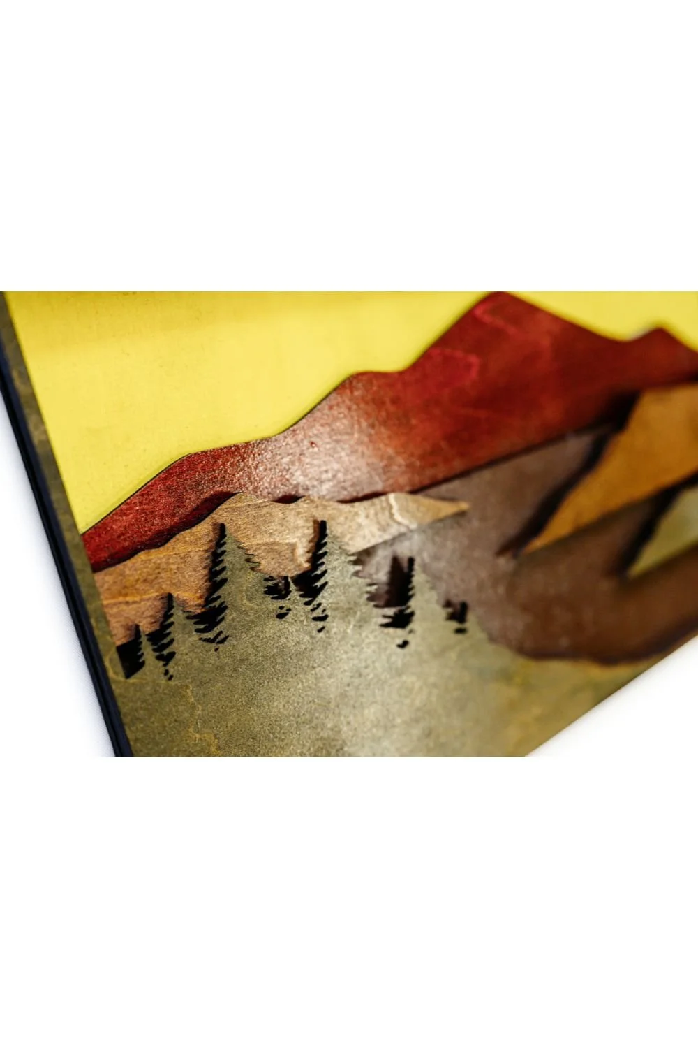 Close-up of mountain scene wood wall art revealing detailed laser-cut trees, mountains, and smooth layered edges