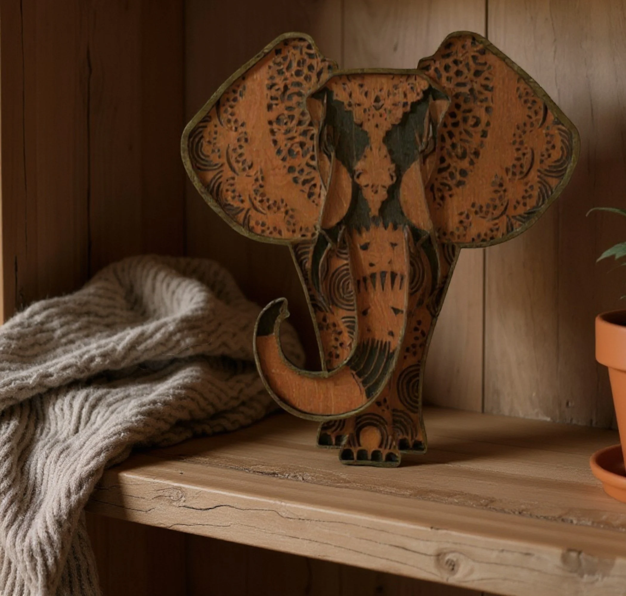 LAYERED WOOD WALL ELEPHANT ON A SHELF.