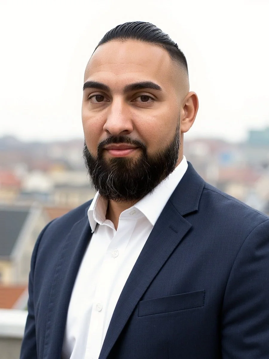 Portriat of Jeff Balfe in a navy suit outside on top of a building.