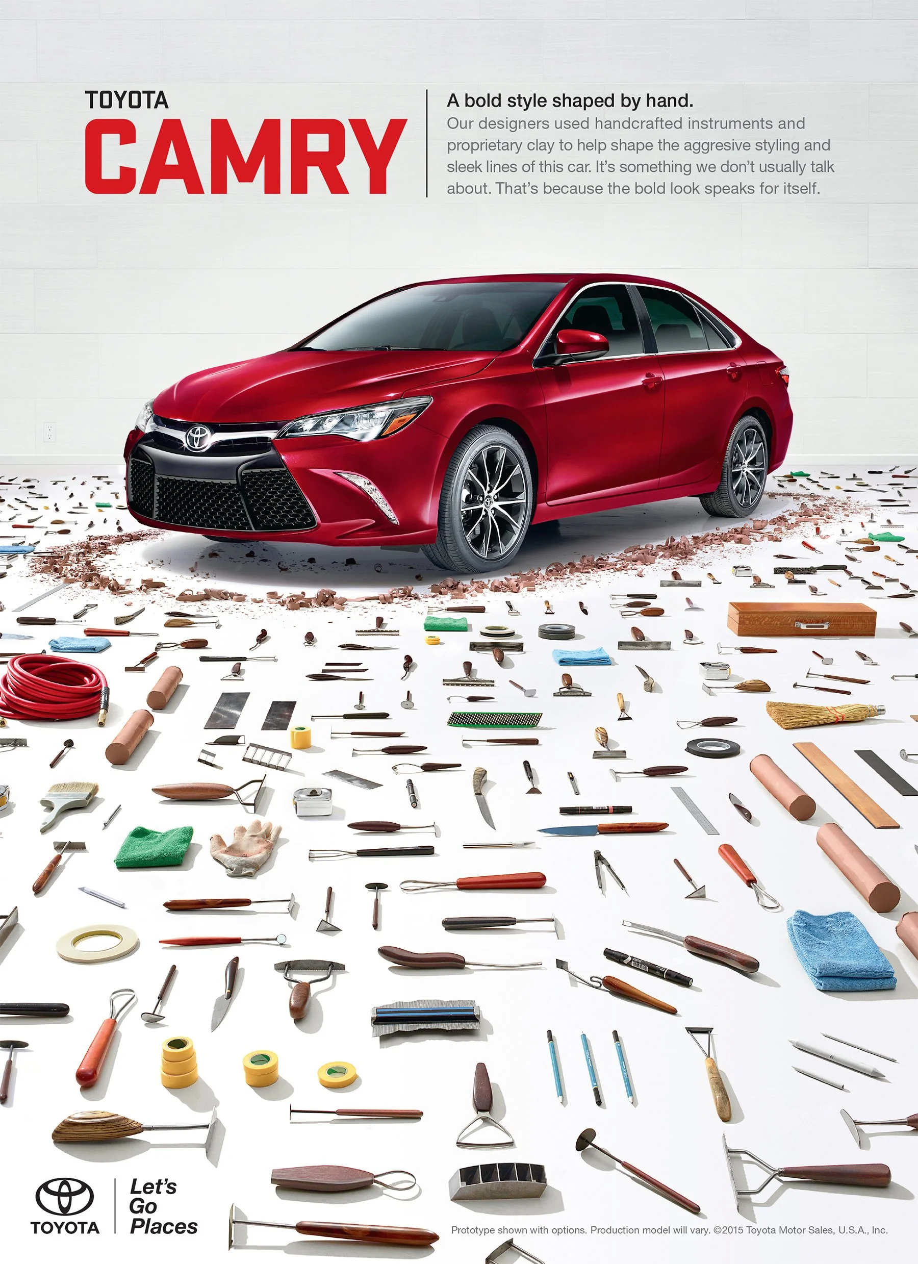 Red Toyota Camry with various car parts and tools laid out on the ground in front of it, advertising vehicle design and craftsmanship.
