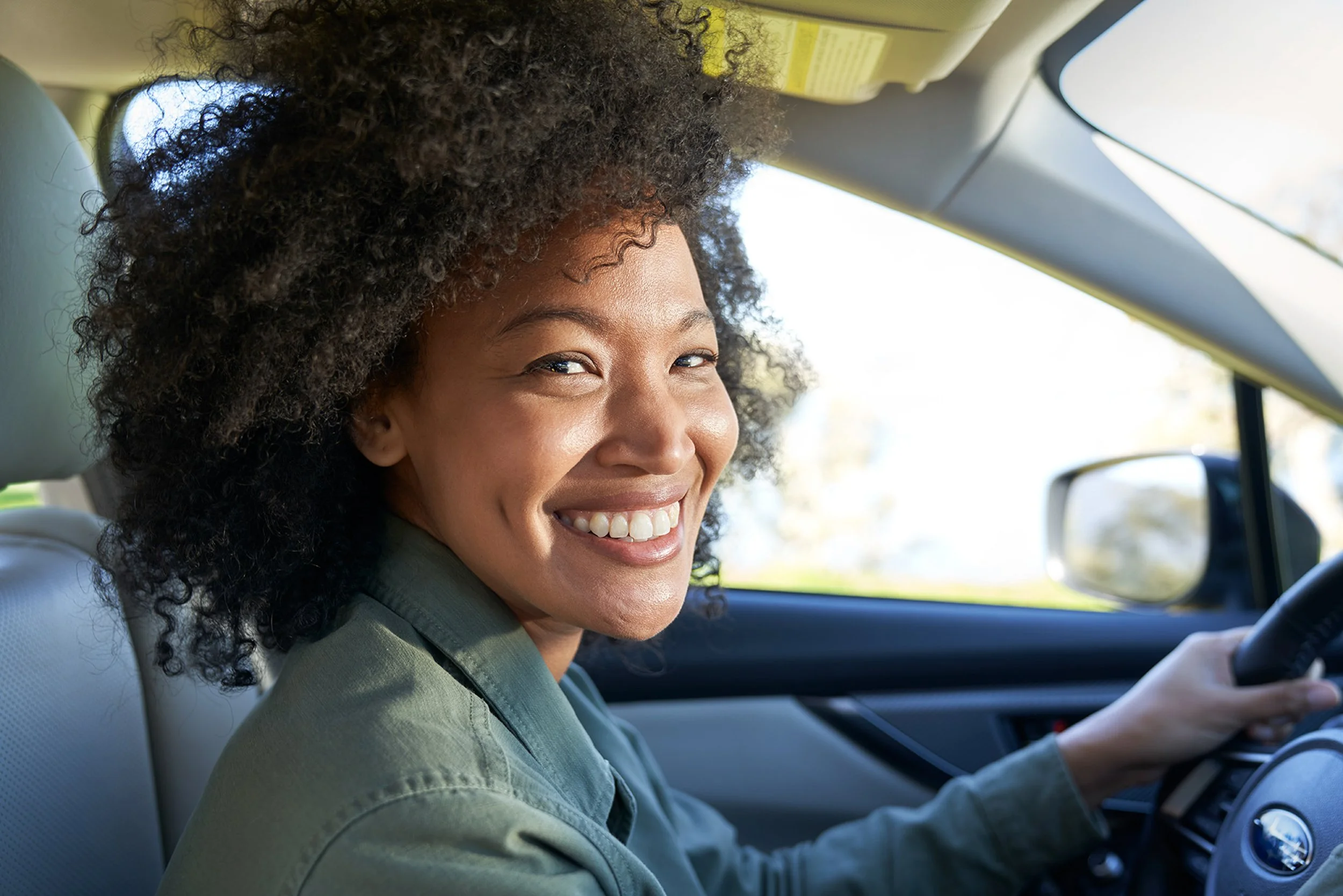 Woman smiling while driving a car.
