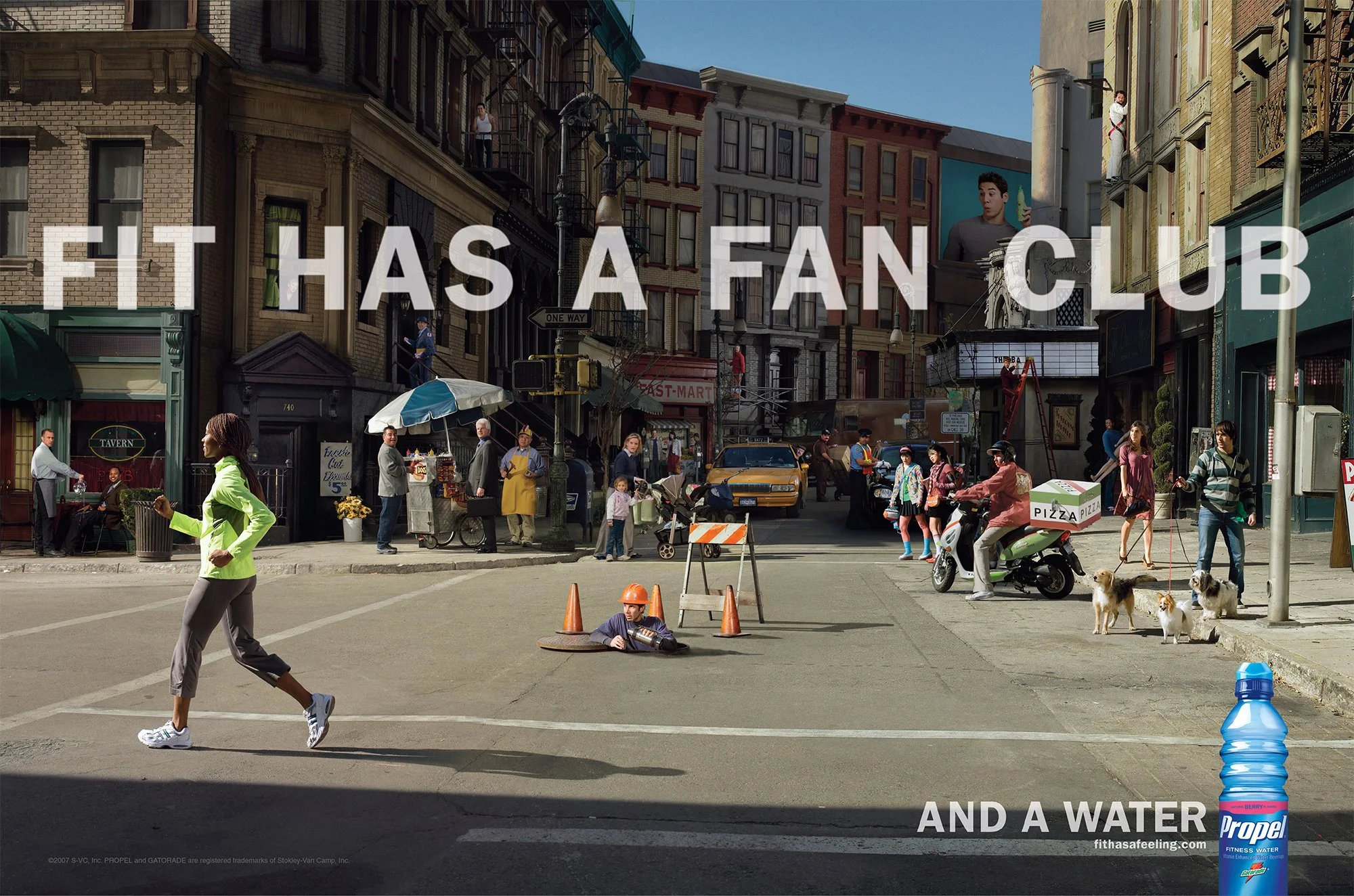 A city street scene with people walking, a person on a scooter, street vendors, and buildings. A woman in a neon green jacket is crossing the street. A worker in an orange helmet is on the ground near traffic cones. There are pedestrians, dogs, and c