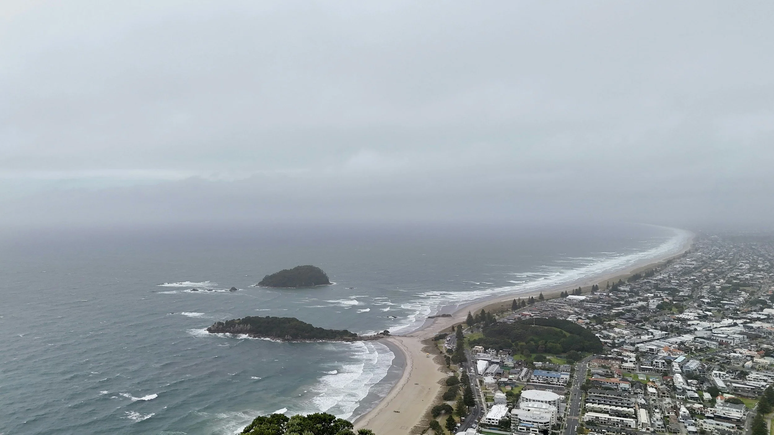 Overhead view of Mount Maunganui main beach and Mount Maunganui main area taken from the top of the Mount.