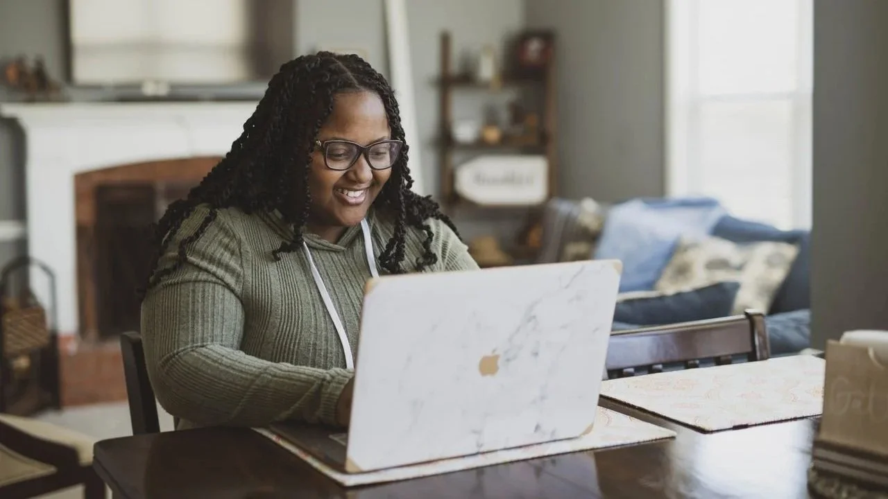 Person smiling while learning from online content.