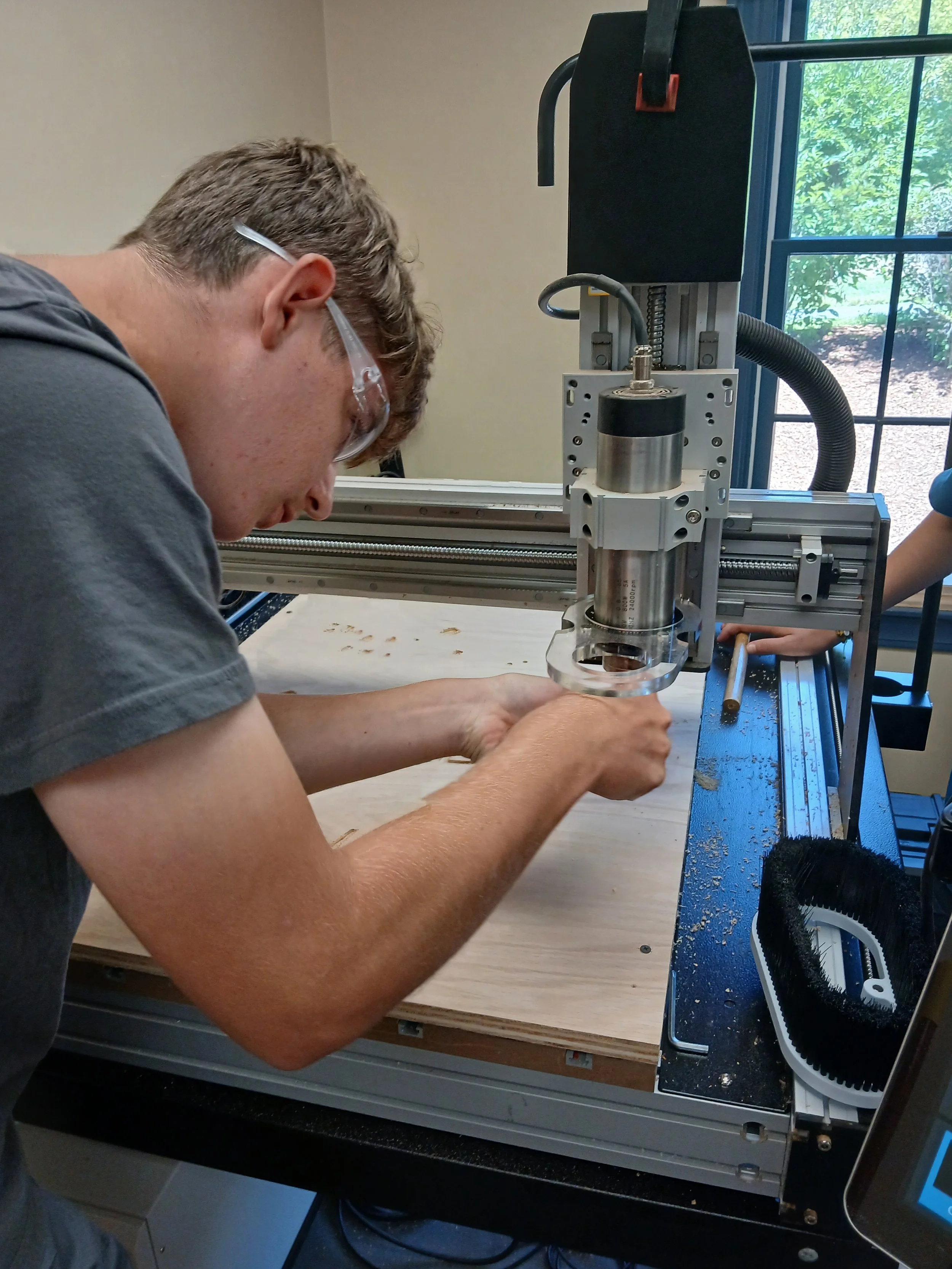A person working on a CNC machine in a workshop.