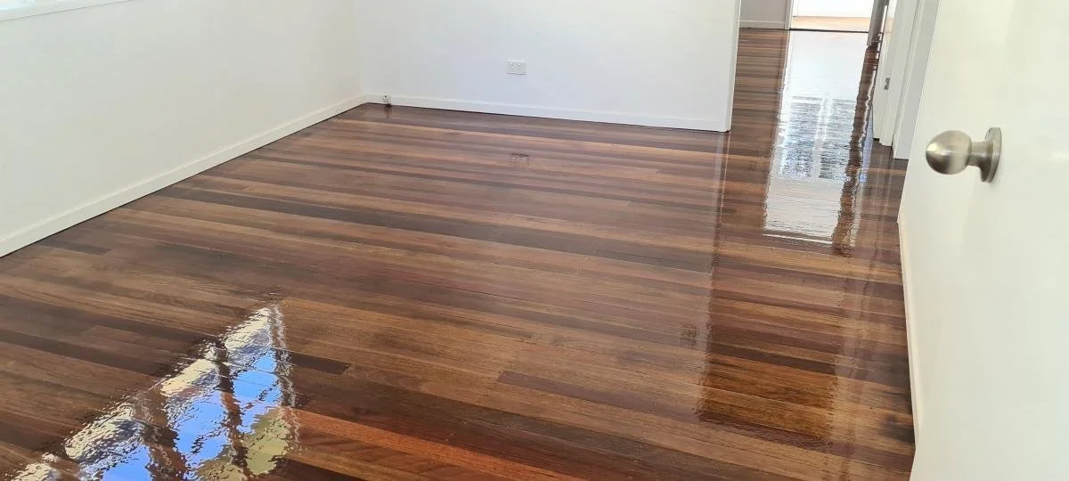 Empty room with polished hardwood floors and white walls