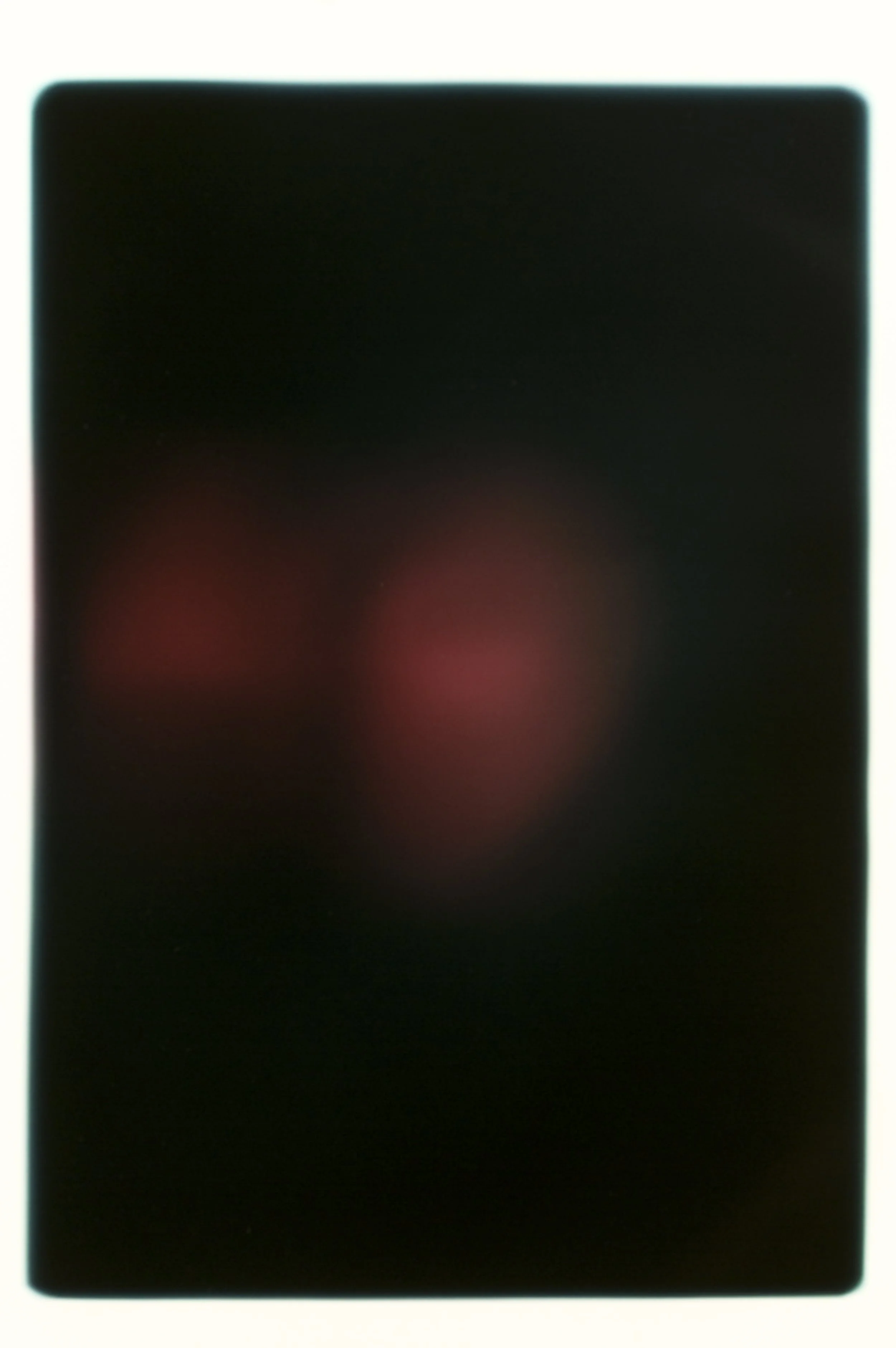 Blurred smartphone screen with glowing red and blue circles against a black background.