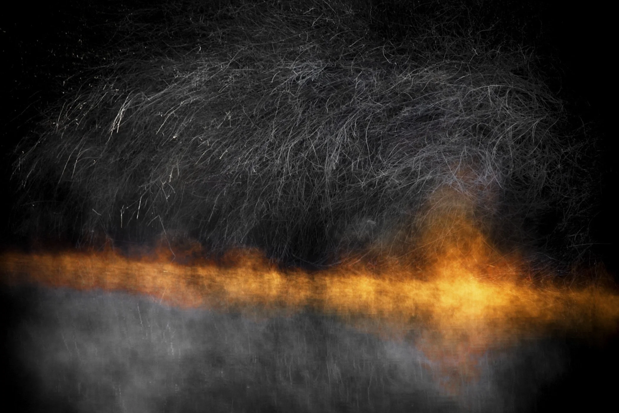 A scene of a large fire with flames and sparks flying, against a dark background.