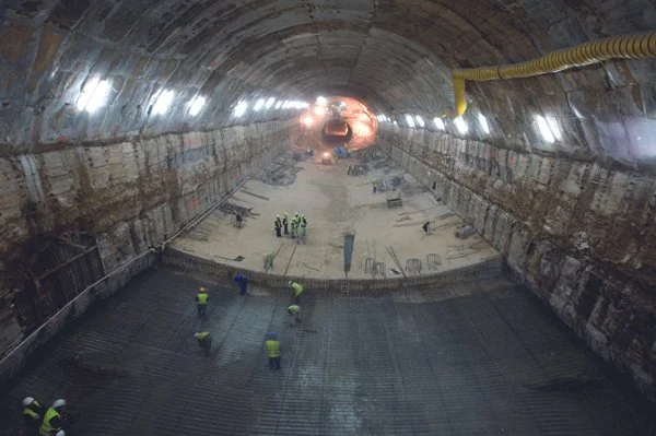 Trabajadores en una construcción dentro de un túnel, colocando estructura de soporte.