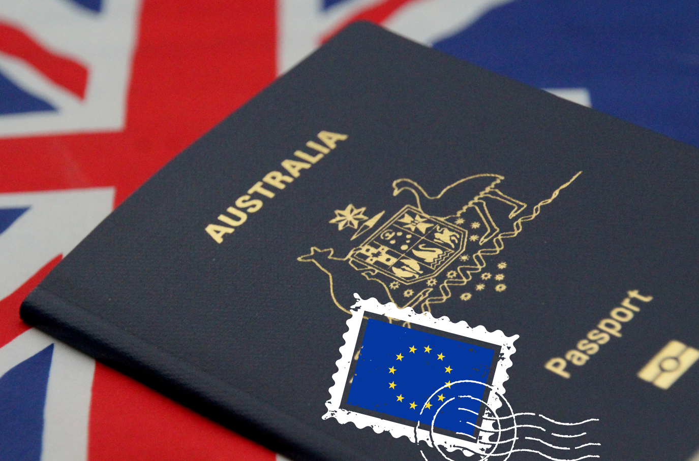 Australian passport with a stamp from the European Union, placed on a surface with a Union Jack flag.– Olympus Migration | Andreas Athanasiou | Australian Visas
