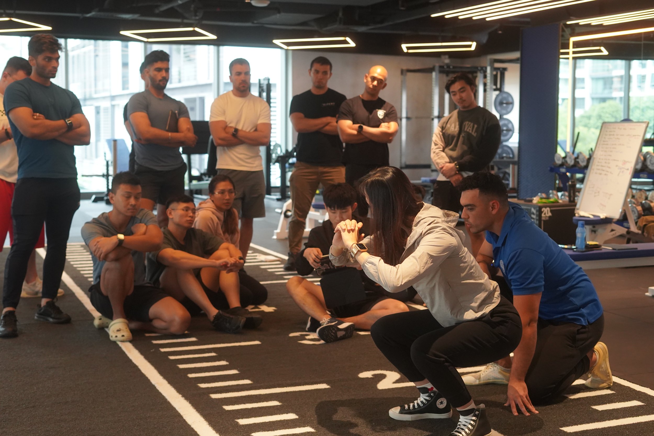 Benny Price demonstrating how limb lengths and joint mobility affect the mechancis of someone's squat during an RTS Level 1 practical workshop in Singapore