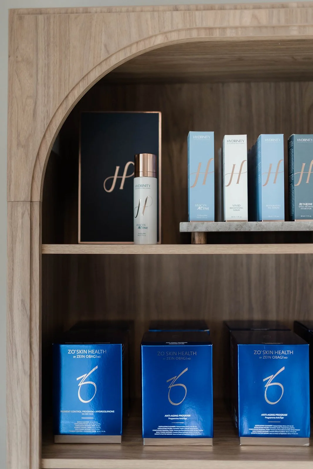 Cloth shelf with skincare products, including boxes labeled 'ZO Skin Health' and bottles with the brand 'Hydrinity'.