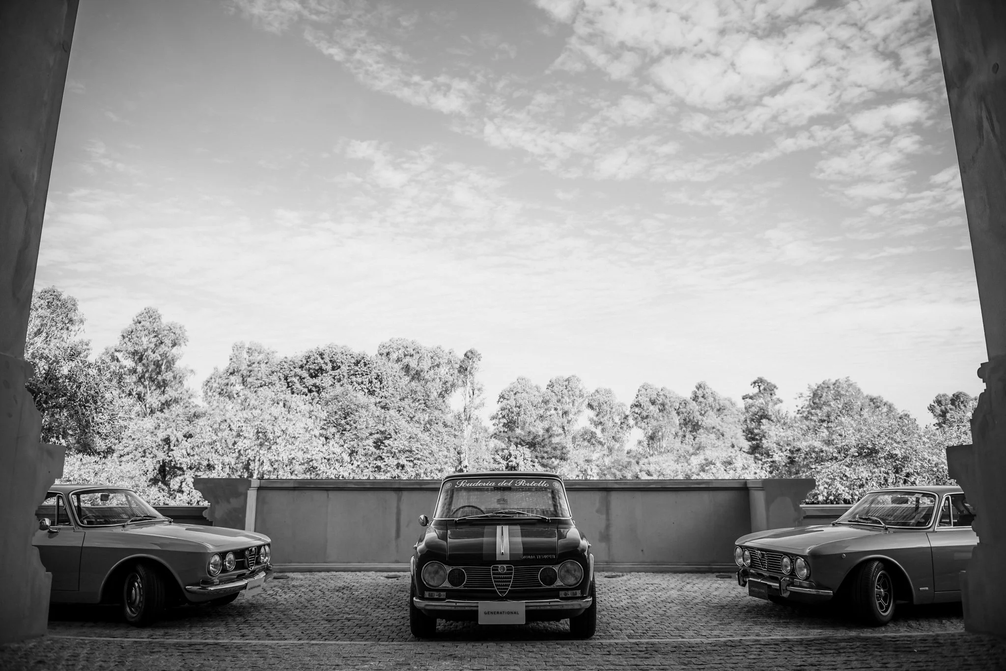 Symmetrical lineup of classic Alfa Romeo sports cars in black and white at Amata Springs Thailand.
