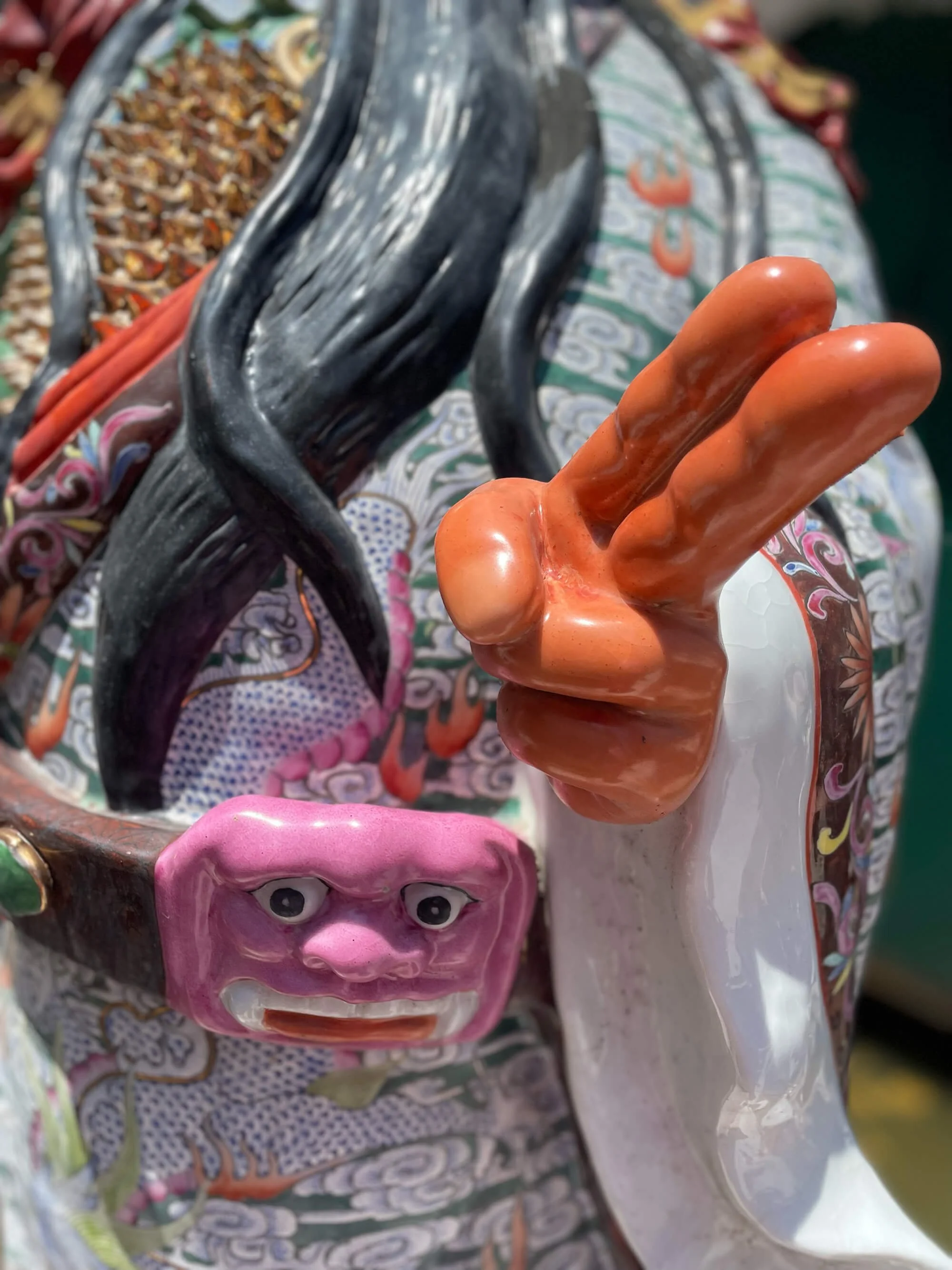 Vibrant hand-sculpted porcelain figure with exaggerated hand gesture, Jingdezhen studio.