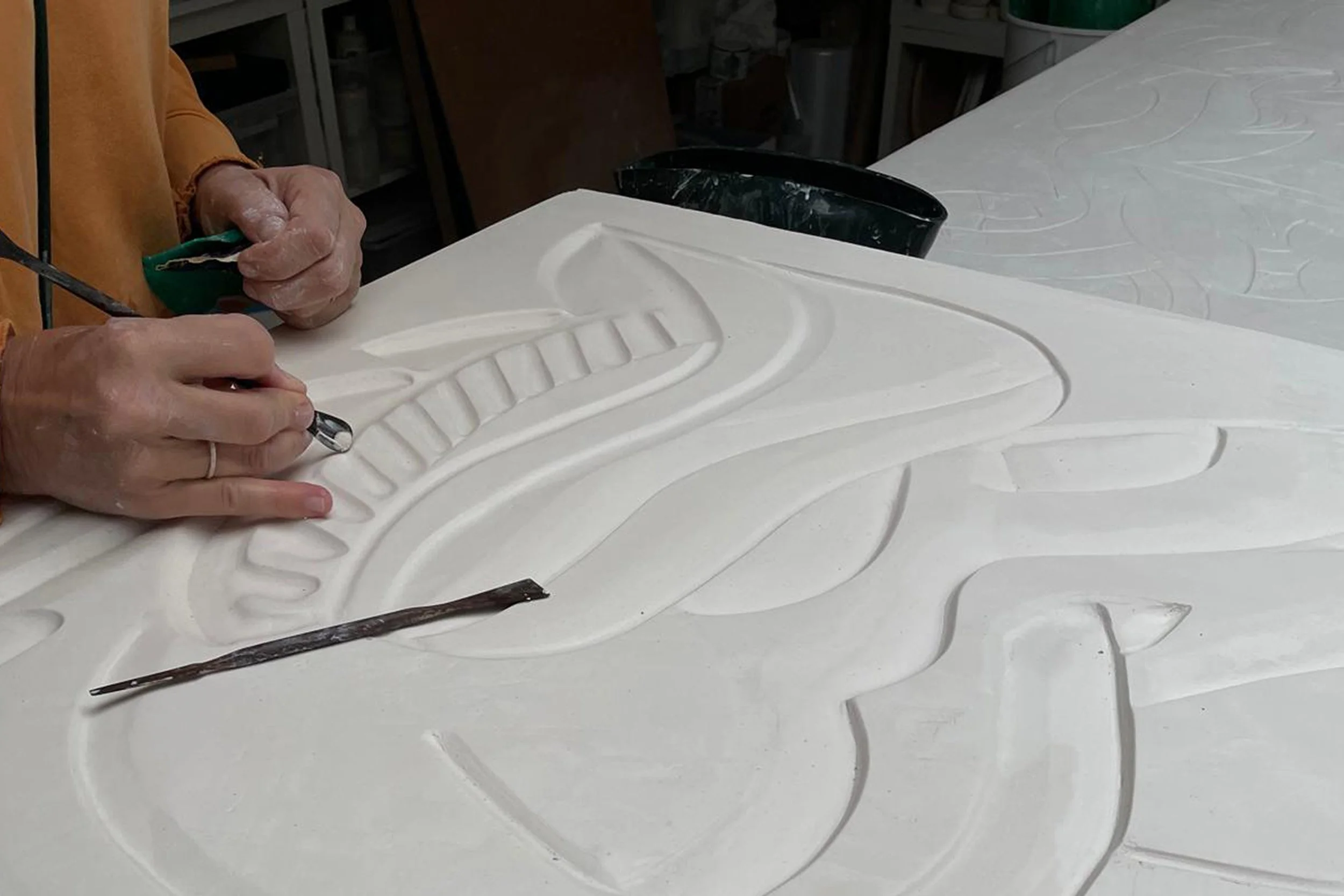 Helen Johannessen carving plaster mural relief in her London studio.
