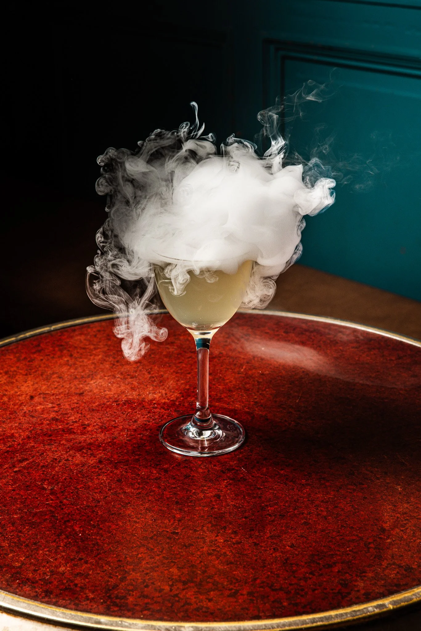 Un verre à cocktail avec de la fumée ou de la vapeur s'échappant du contenu.