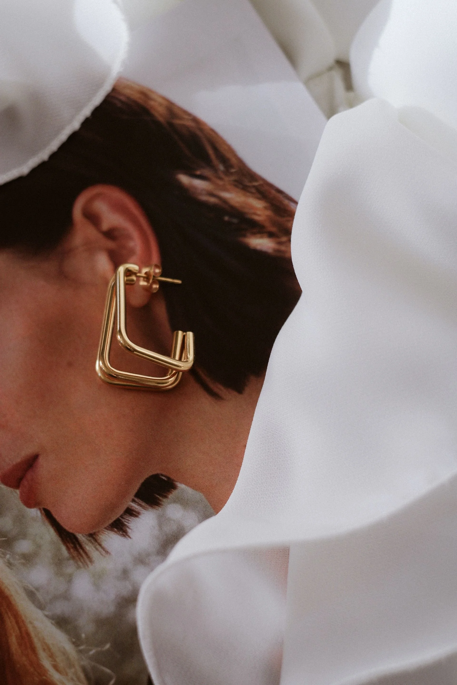 Model wearing architectural fine jewelry—structured geometric earrings that blend modern design with heirloom craftsmanship.