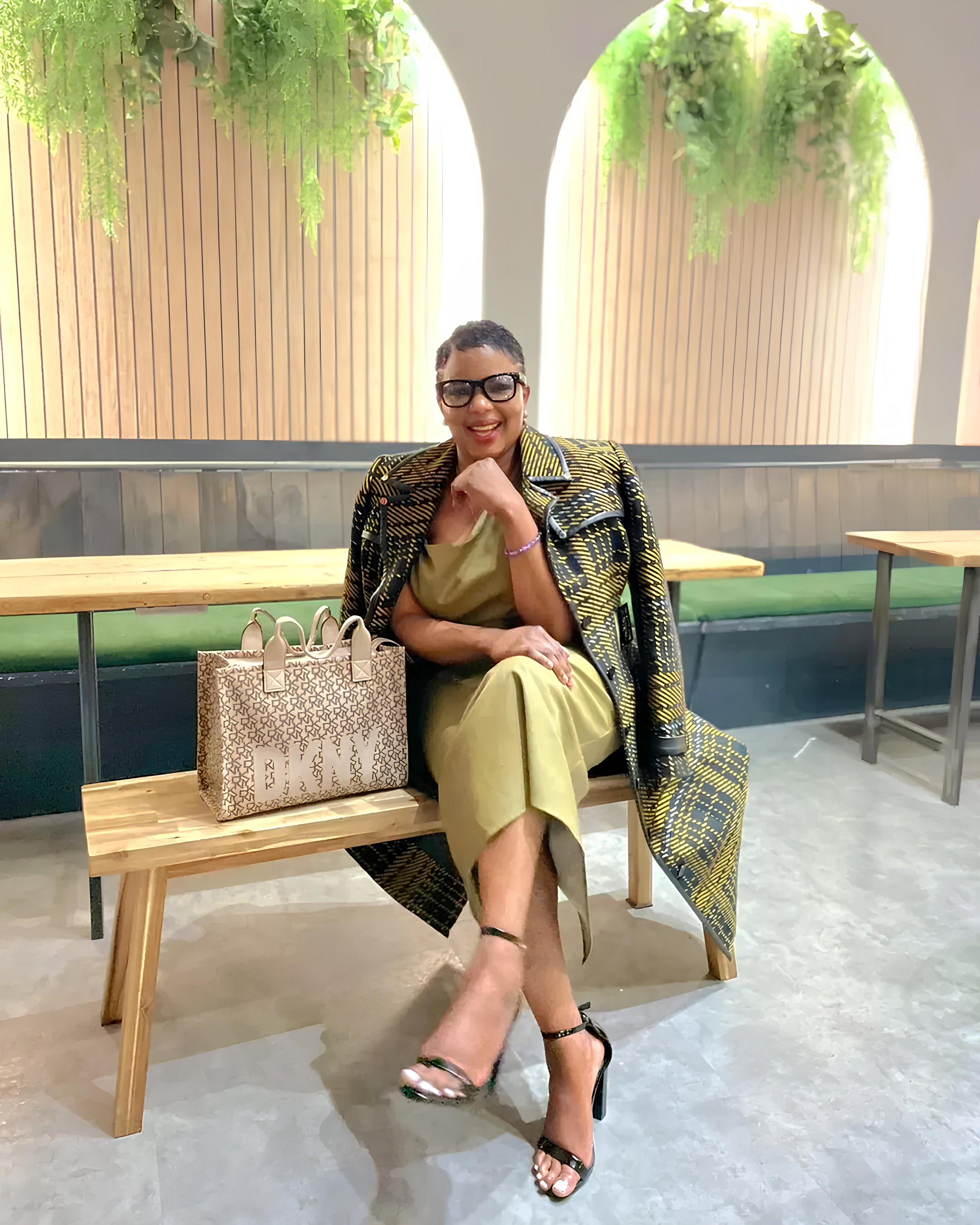 A modern house on a green hillside with snow-capped mountains in the background.