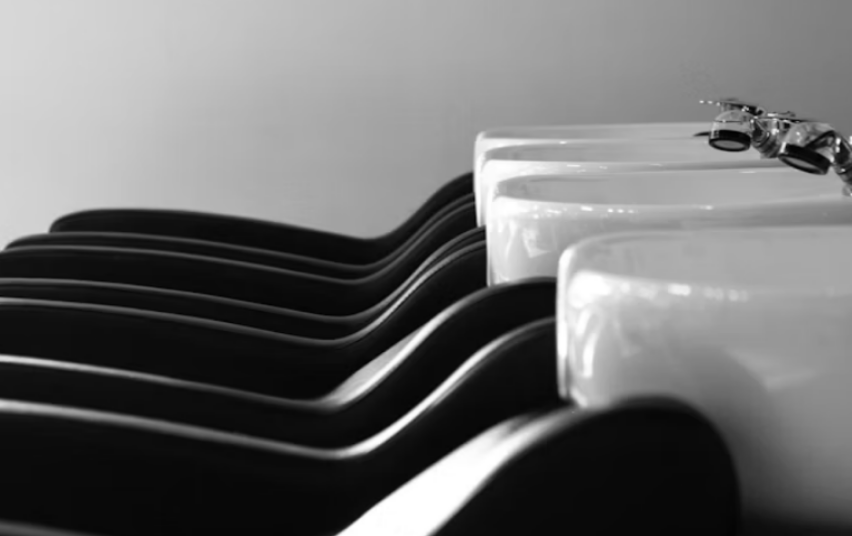 Close-up of black and white electric guitars lined up side by side.