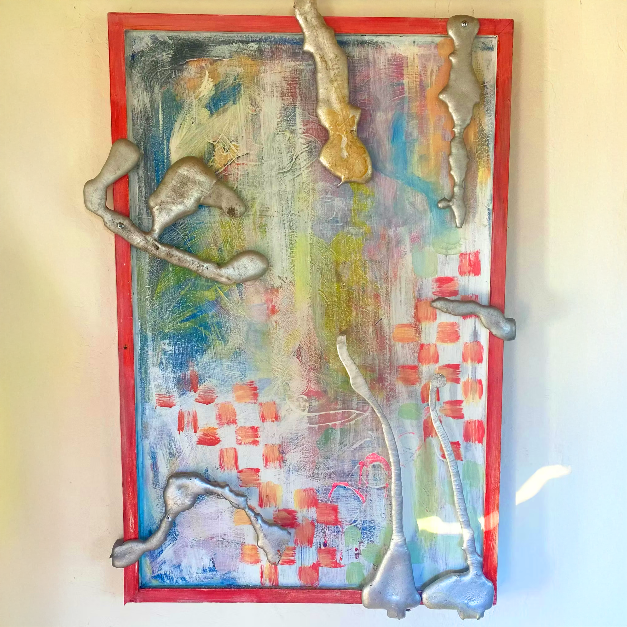 Abstract painting with colorful brushstrokes and six metallic, irregularly shaped objects attached to the frame.