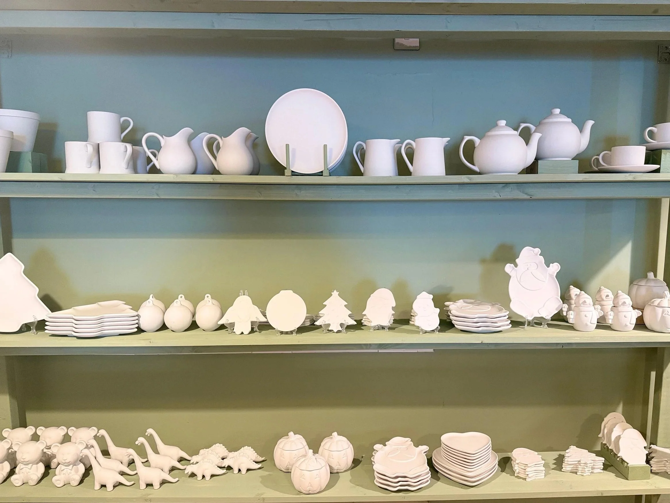 Shelves of unpainted ceramic mugs, teapots, plates and ornaments to choose from at Designs Café in Dartington