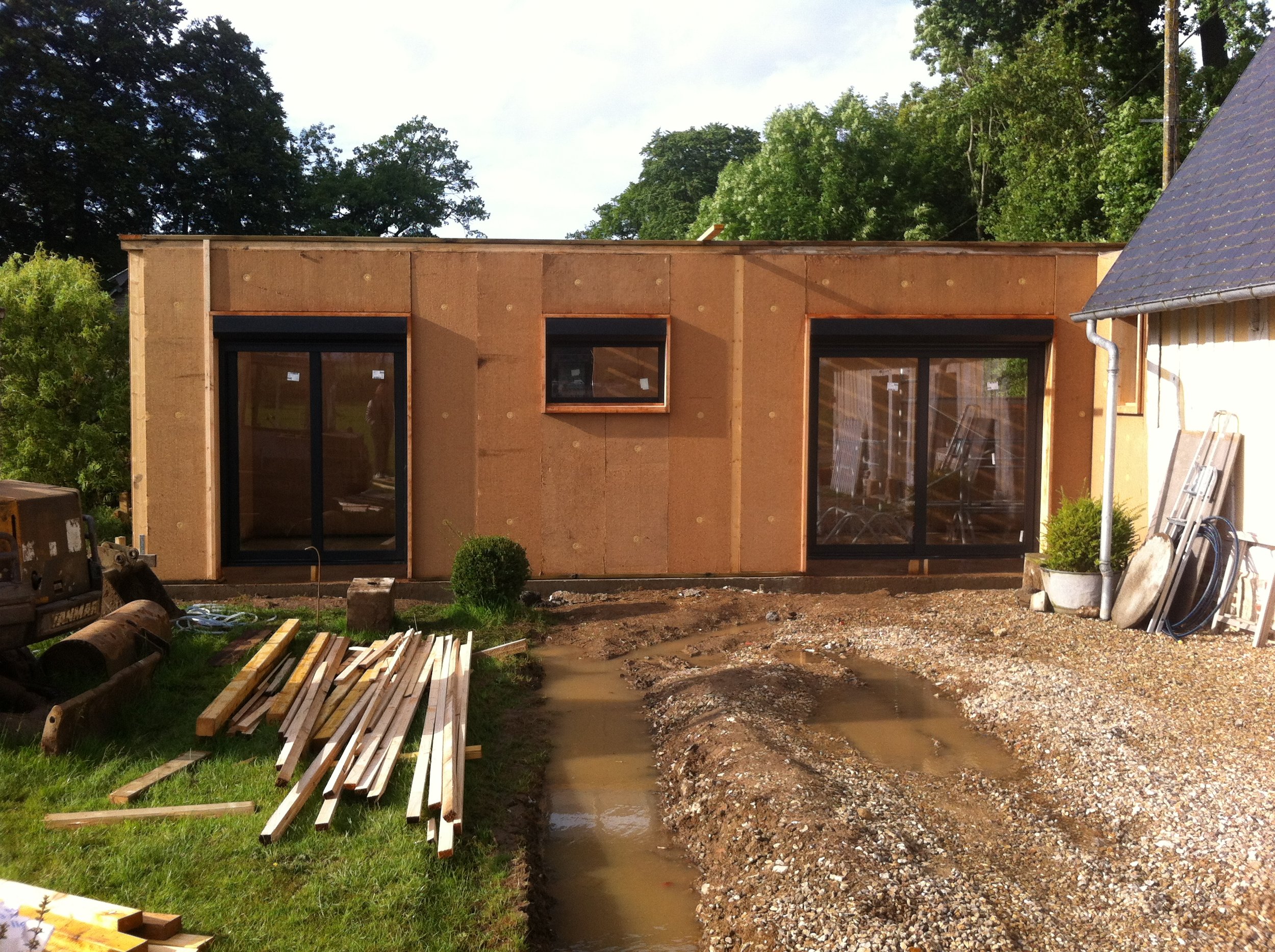 Construction d'une extension en bois d'une maison avec des fenêtres en verre.
